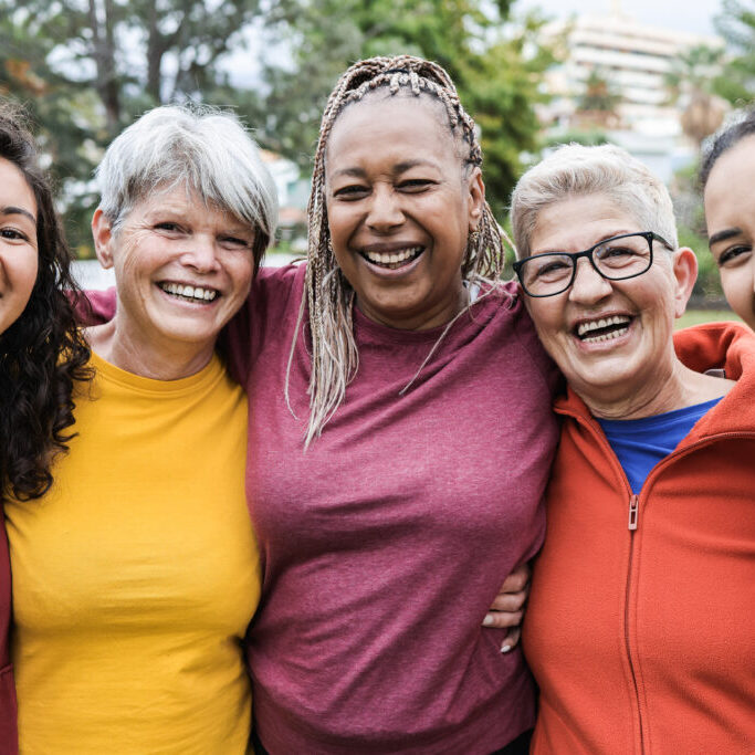 Happy multi generational women having fun together - Multiracial friends smiling on camera after sport workout outdoor - Main focus on african female face