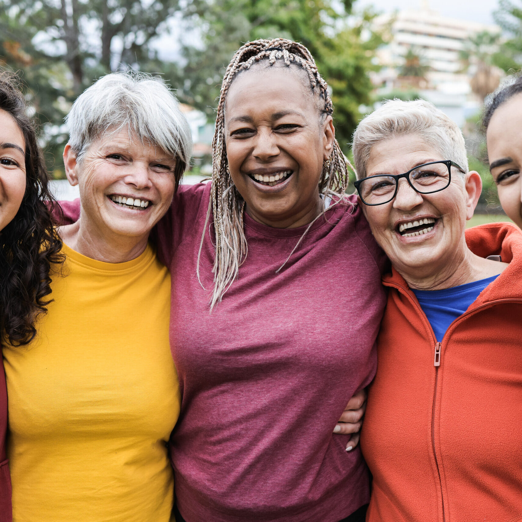 Happy multi generational women having fun together - Multiracial friends smiling on camera after sport workout outdoor - Main focus on african female face