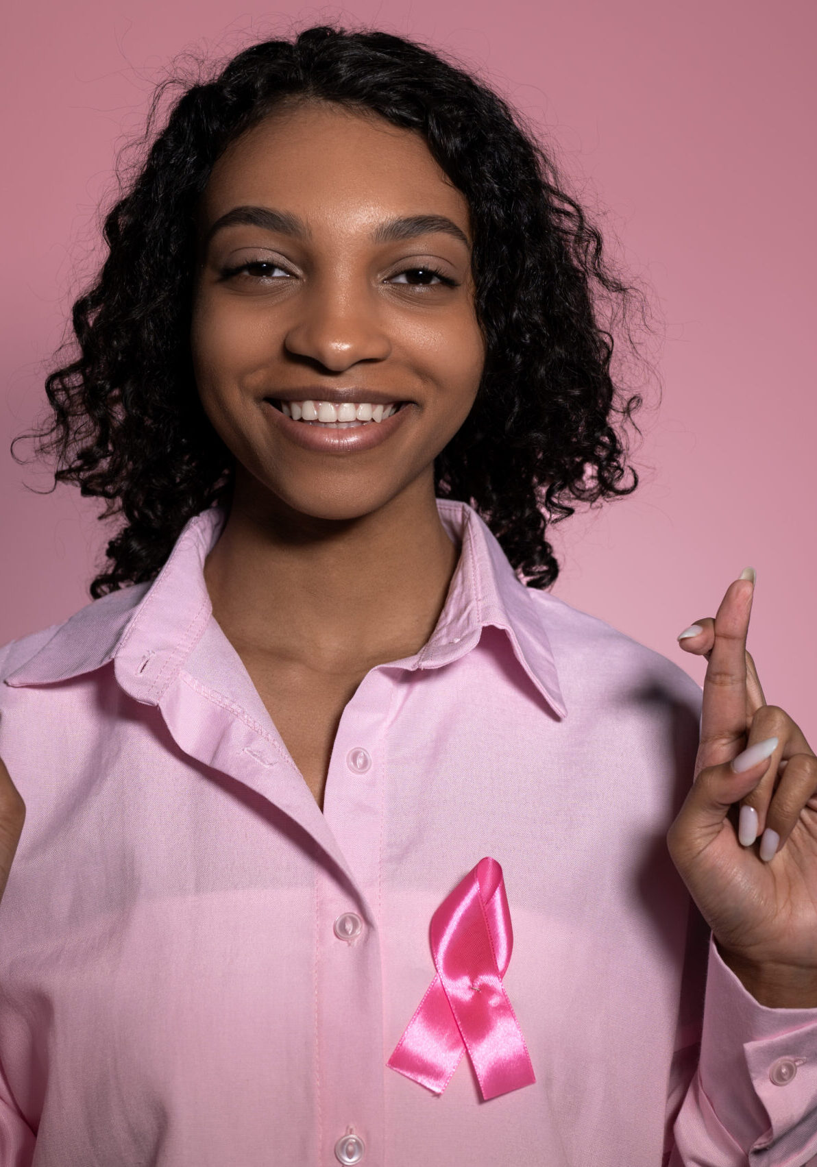 Happy ,smiling breast cancer survivor girl against pink background. High quality photo